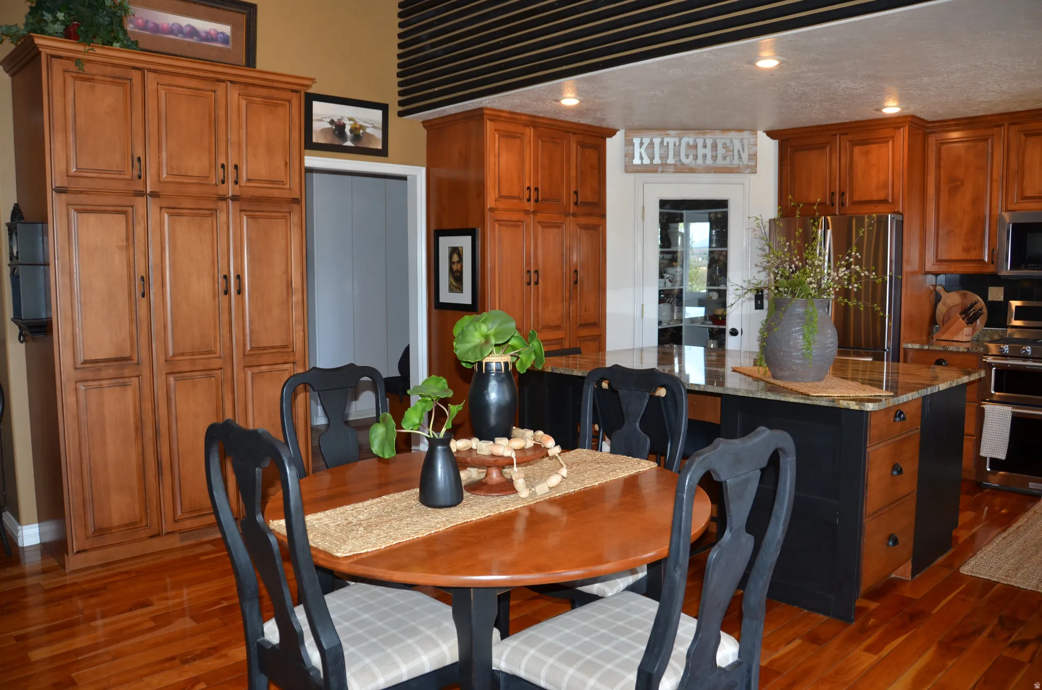 Kitchen area featuring wood flooring, recessed lighting, and rich wood cabinetry