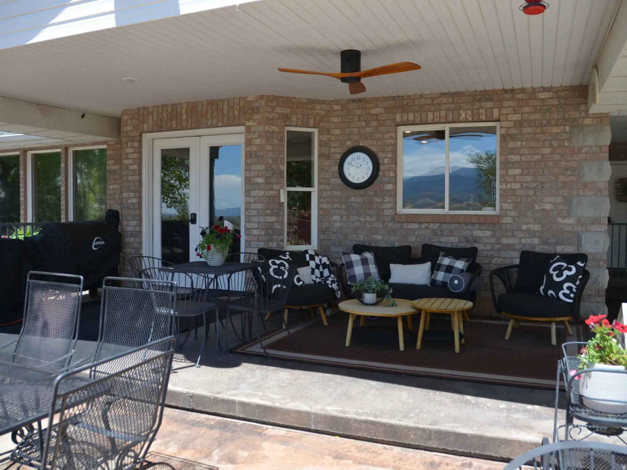 Covered patio featuring brick exterior, white French doors, a built-in ceiling fan, and recessed lighting