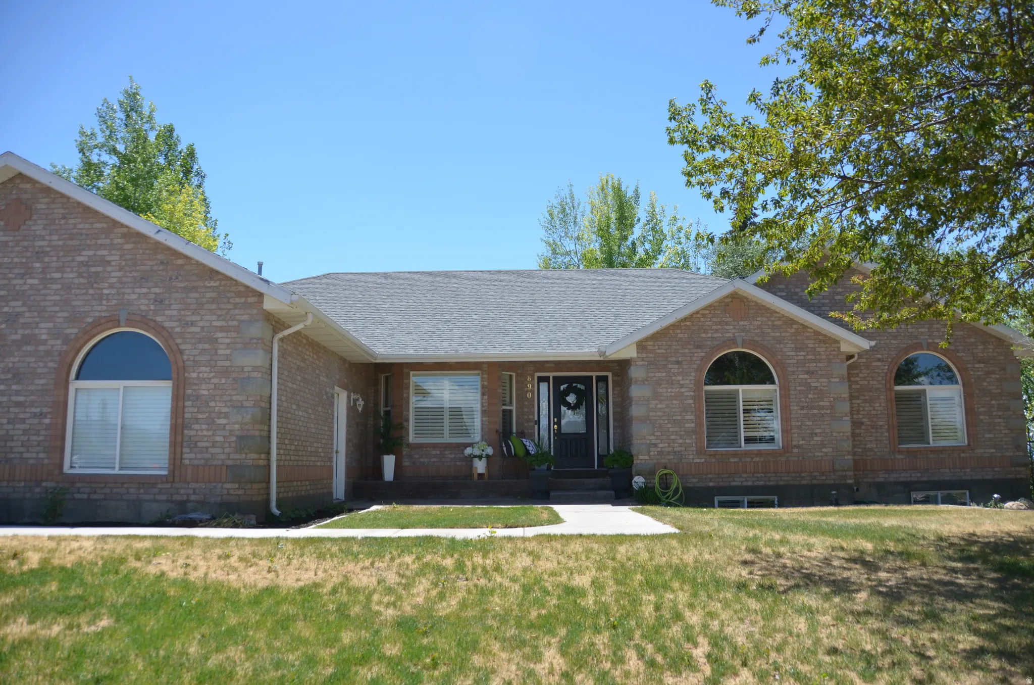 Brick exterior featuring a gabled roofline and a dark entry door