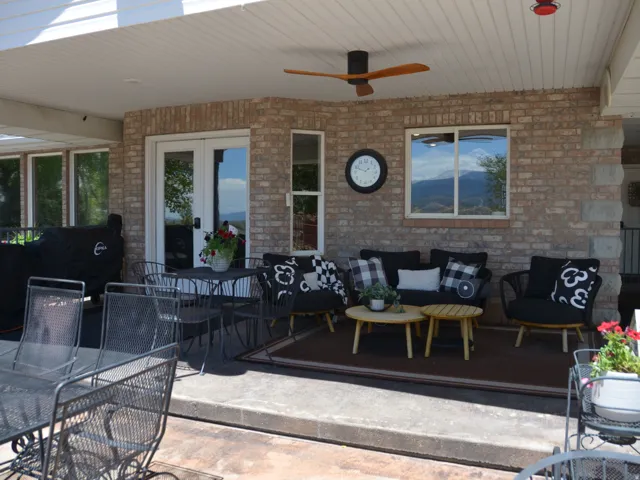 Covered patio featuring brick exterior, white French doors, a built-in ceiling fan, and recessed lighting