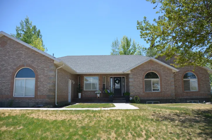 Brick exterior featuring a gabled roofline and a dark entry door