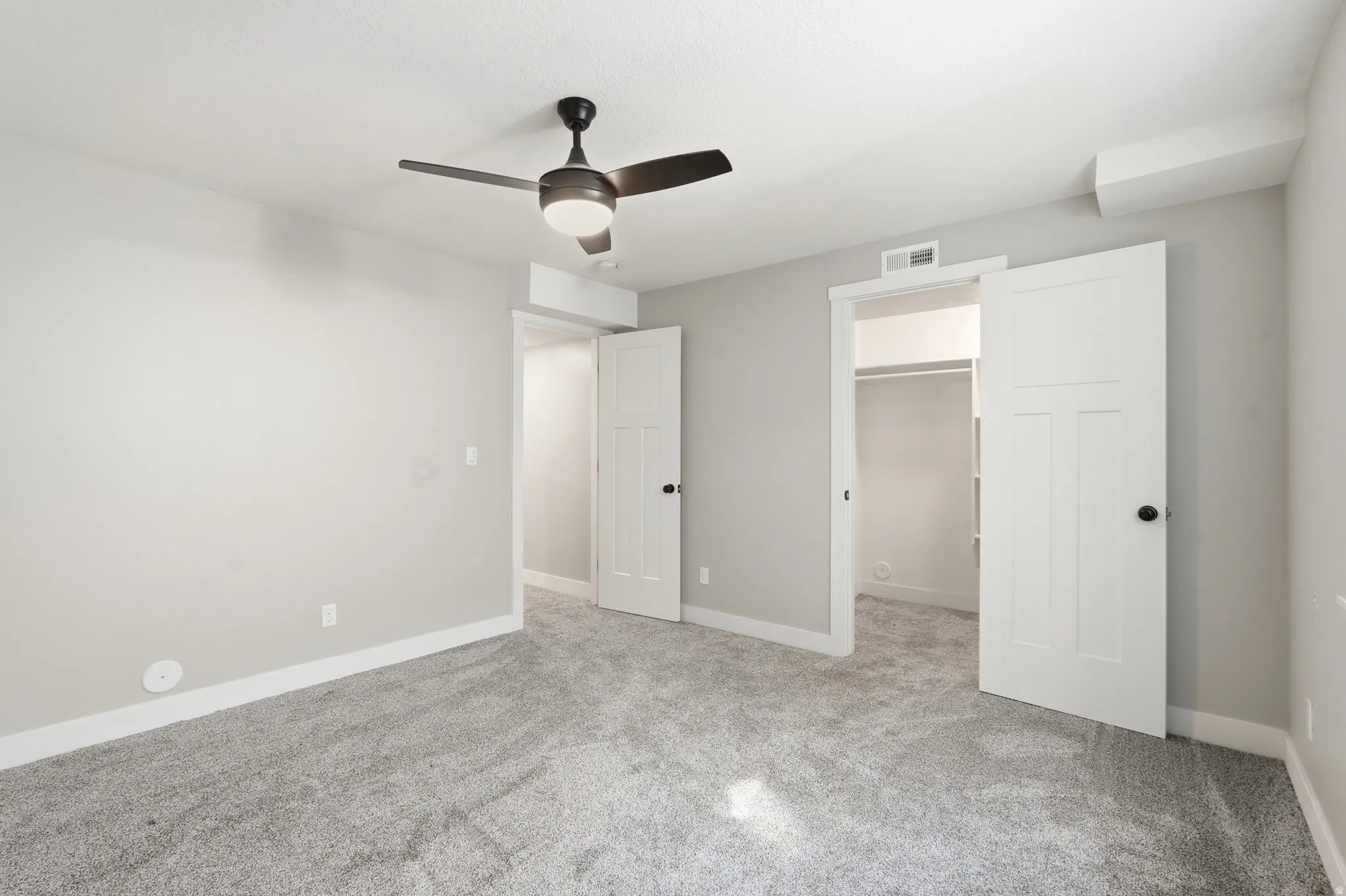 Neutral tone wall finishes with plush gray carpeting