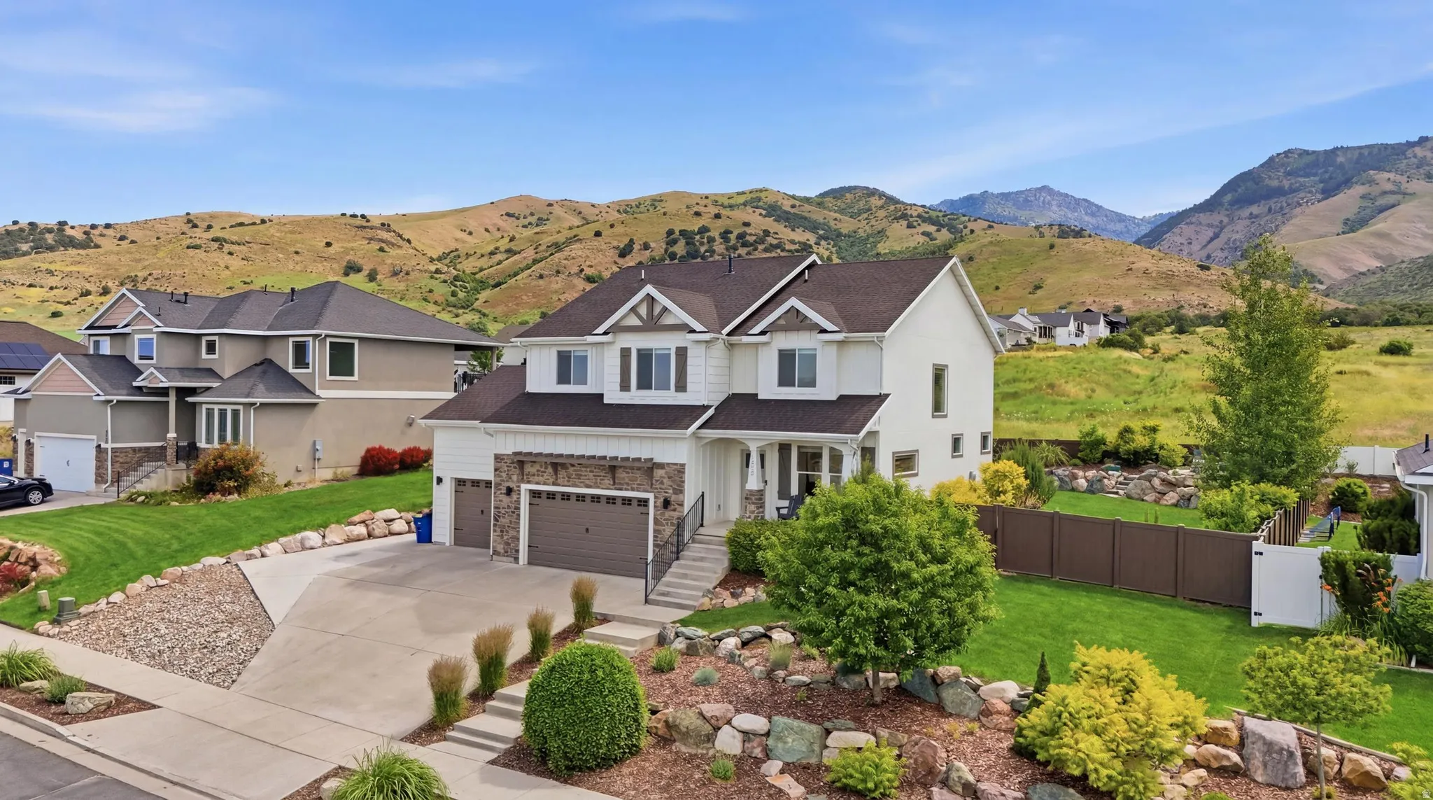 Two-story residence featuring a two-car garage, stone veneer accents, and a covered entry