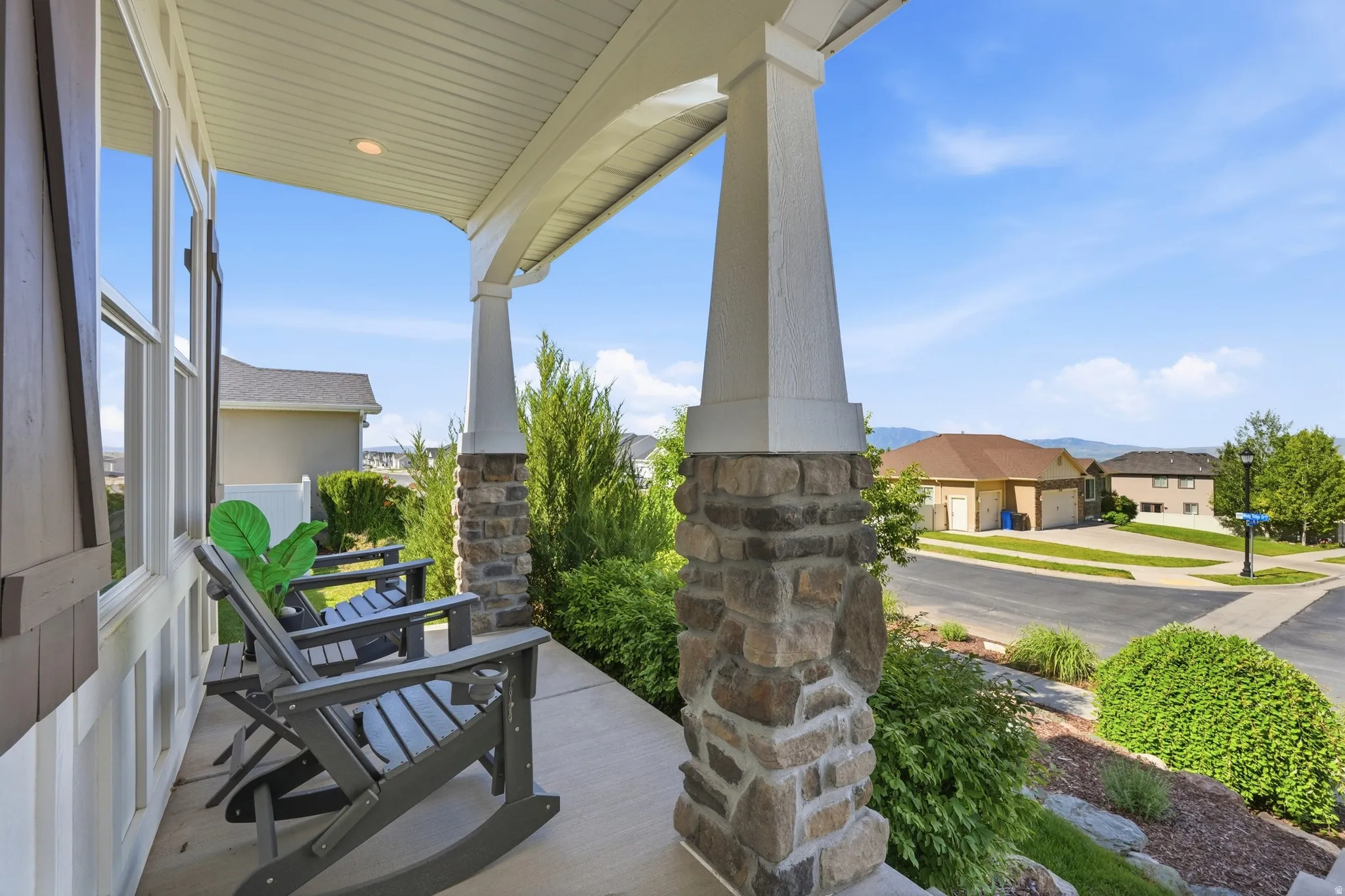 Covered porch with stone-clad columns and recessed lighting