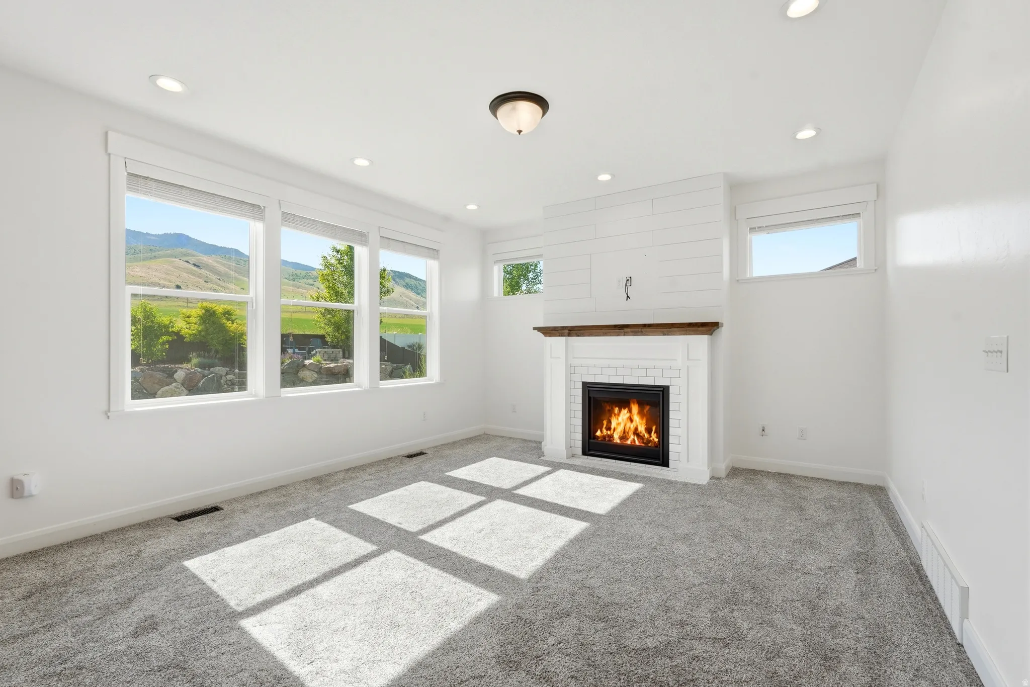 Living area with a fireplace featuring a white subway tile surround and a wood mantel