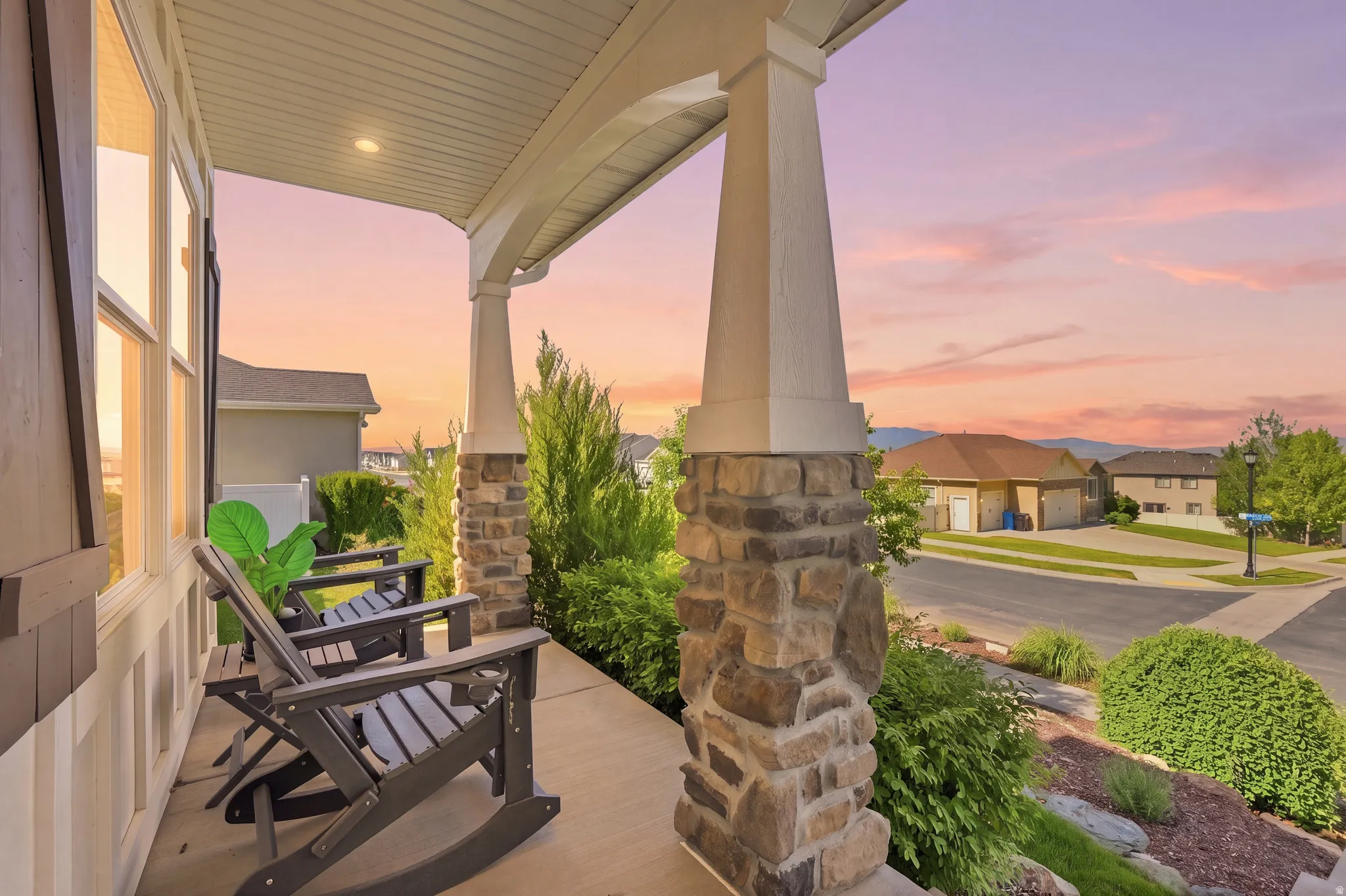 Expansive covered porch featuring stone-clad columns, recessed lighting, and a concrete surface