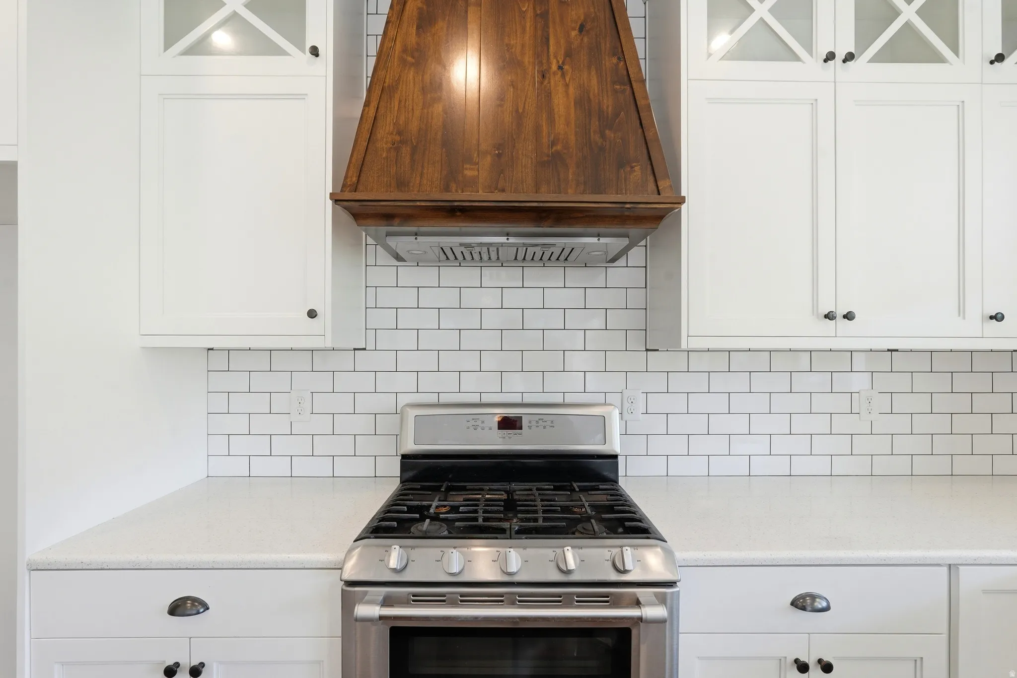 Stainless steel gas range with a wood-finish range hood