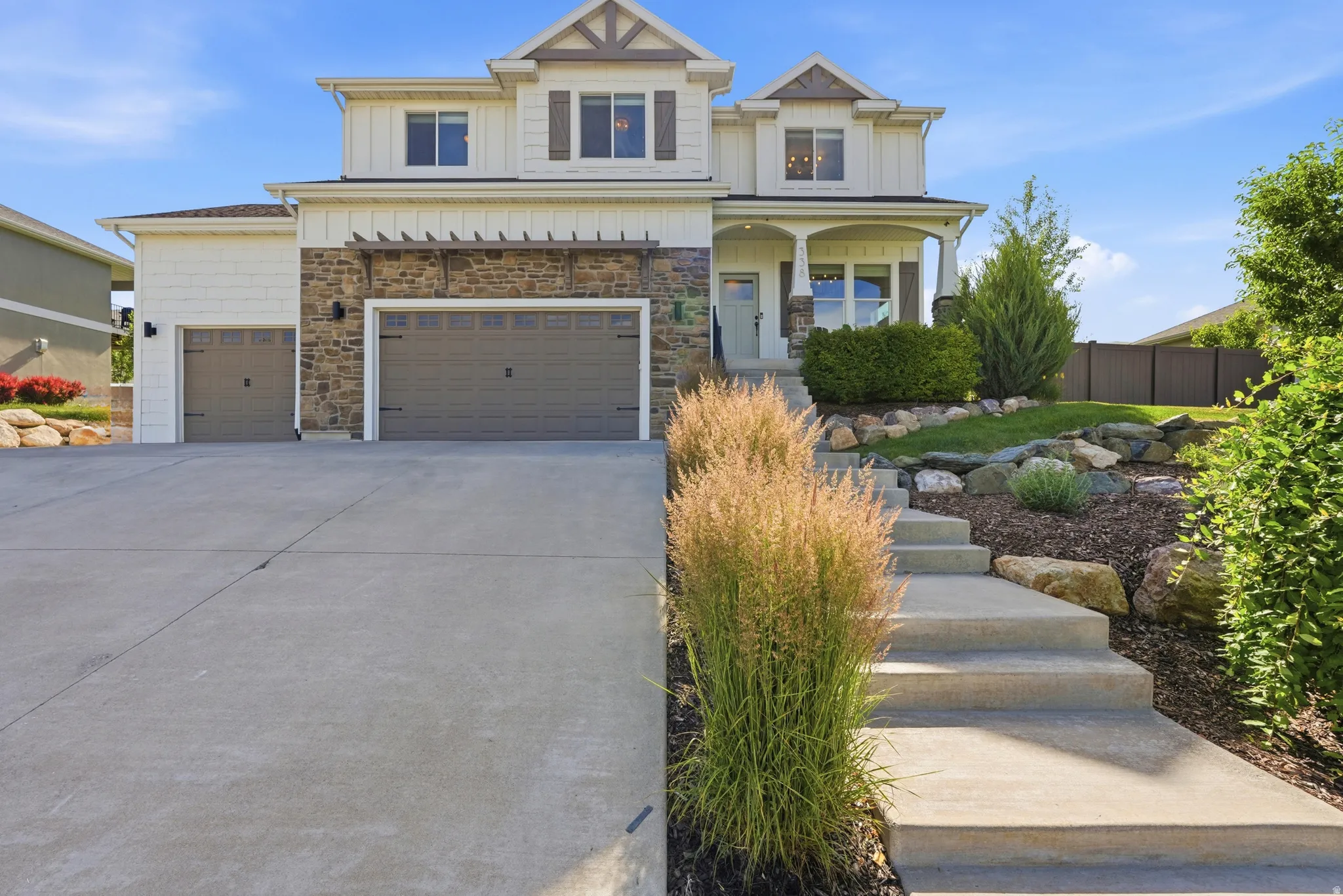 Two-story residence featuring a mixed-material facade with stone accents and vertical siding