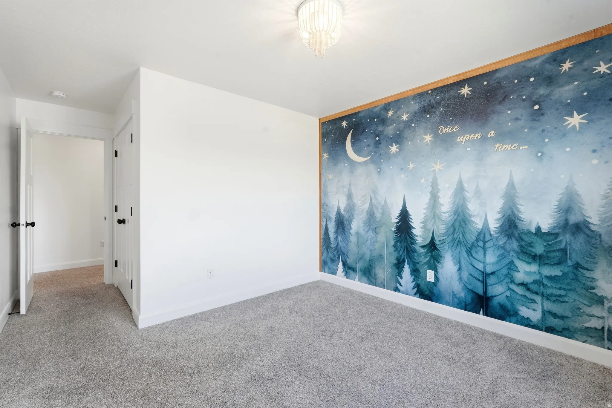 Interior room featuring a decorative wall mural with a forest and night sky design