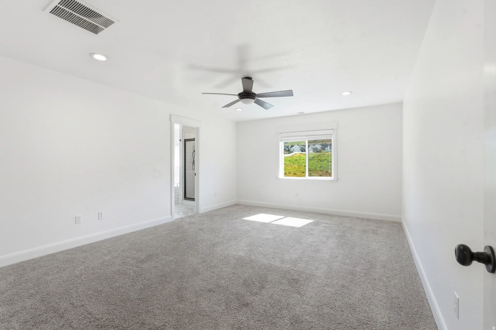 Spacious room with gray carpet flooring and white walls