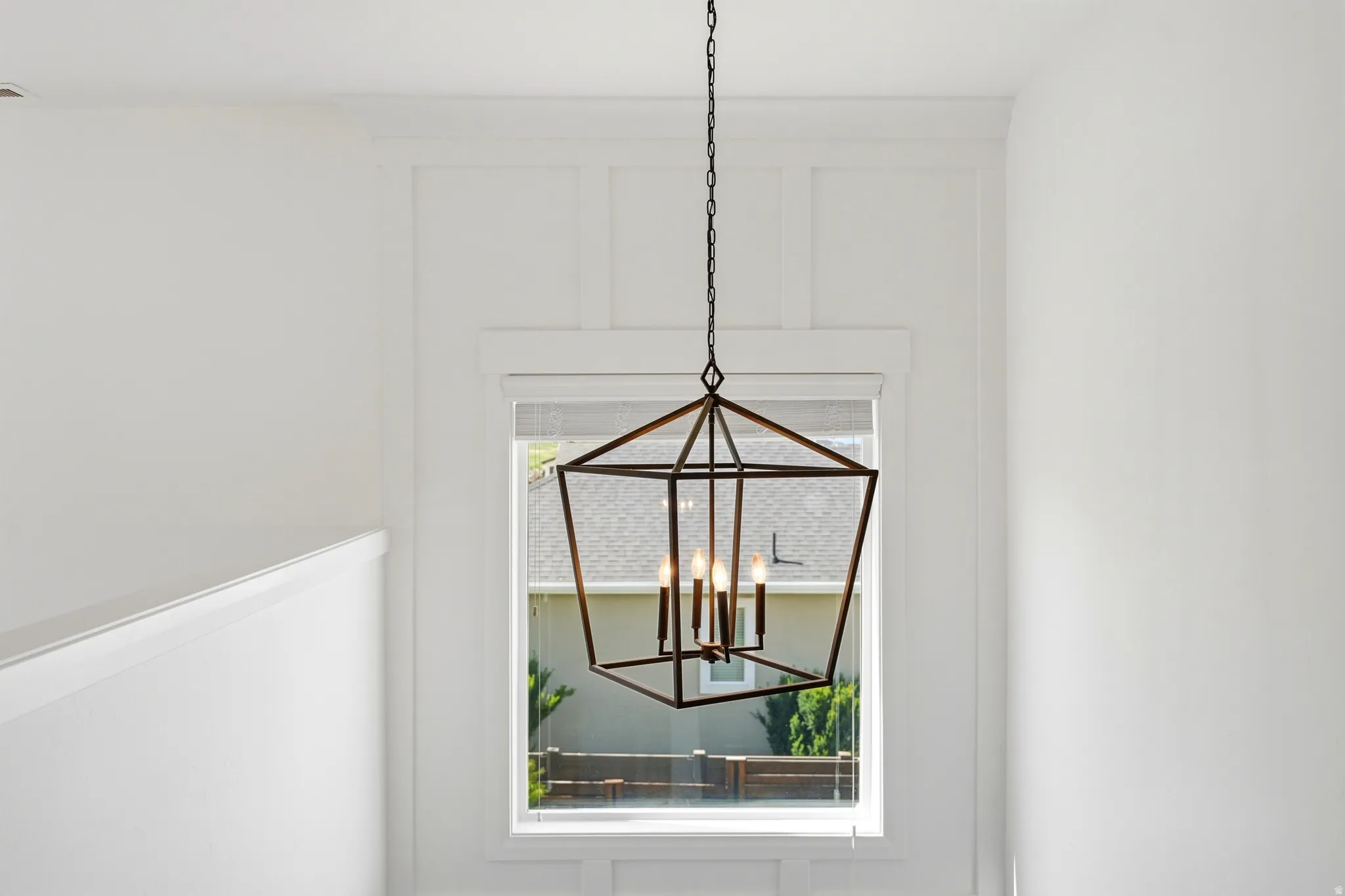 Geometric chandelier illuminating a window with board and batten wall detailing