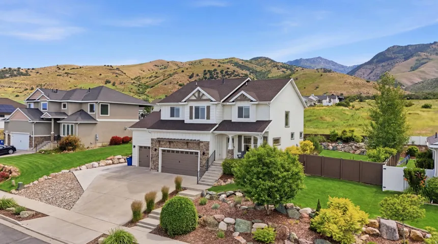Two-story residence featuring a two-car garage, stone veneer accents, and a covered entry