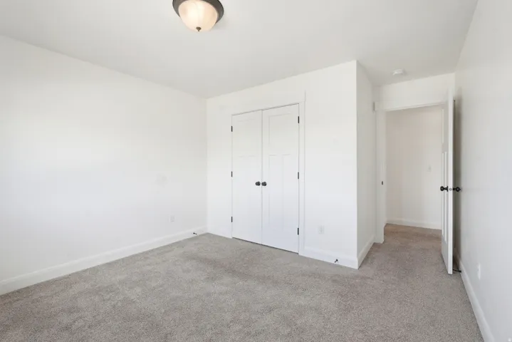 Neutral-toned carpet flooring and white walls