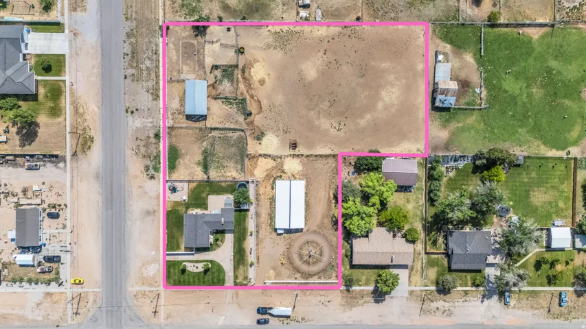 Expansive lot featuring a single-family residence with a covered patio, manicured front lawn, and paved driveway