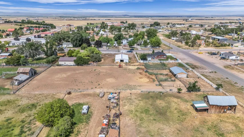 Expansive property featuring multiple outbuildings, fencing, and a combination of cleared and vegetated land