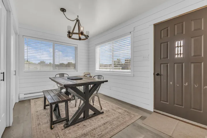 Entryway featuring a panel door with window inserts, shiplap wall accents, and wood-finish flooring