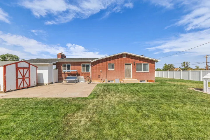 Expansive green lawn with a white privacy fence