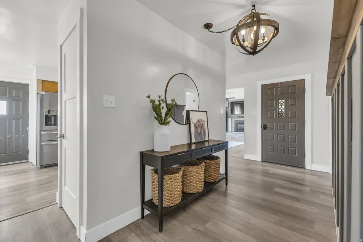Entryway featuring wood-finish flooring, white walls, and a decorative front door with an ornate glass insert