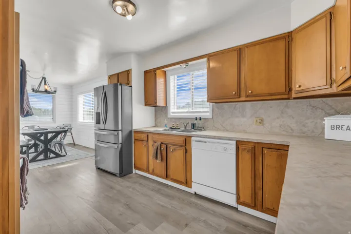 Kitchen featuring wood-finish cabinetry, light-toned countertops, and a full backsplash