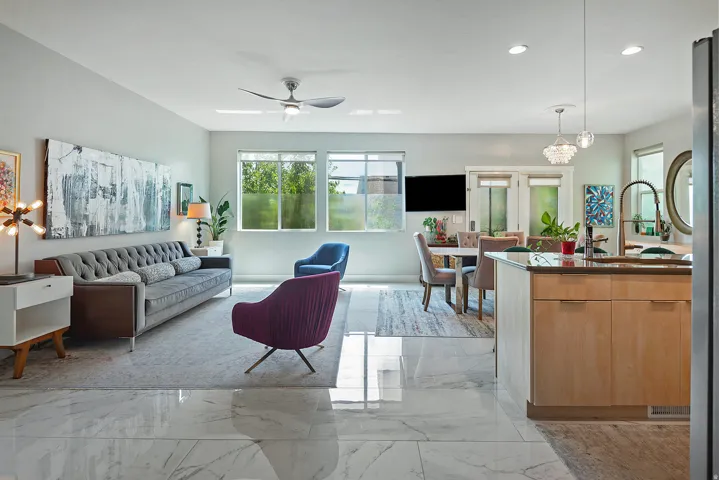 Spacious open-concept living area featuring large format marble-look tile flooring