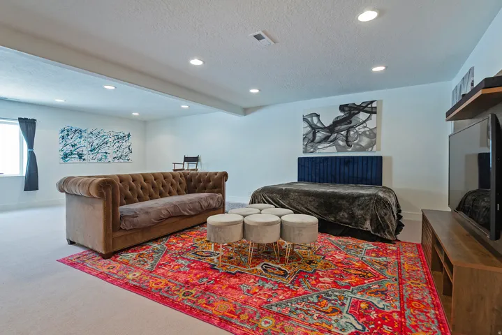 Open-concept space featuring recessed lighting and light-toned wool carpeting