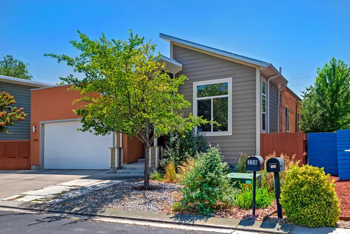 Modern residence featuring a sloped roofline, attached garage, and a blend of horizontal siding and stucco finishes