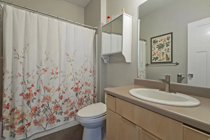 Bathroom vanity with integrated sink, brushed nickel faucet, and neutral countertop