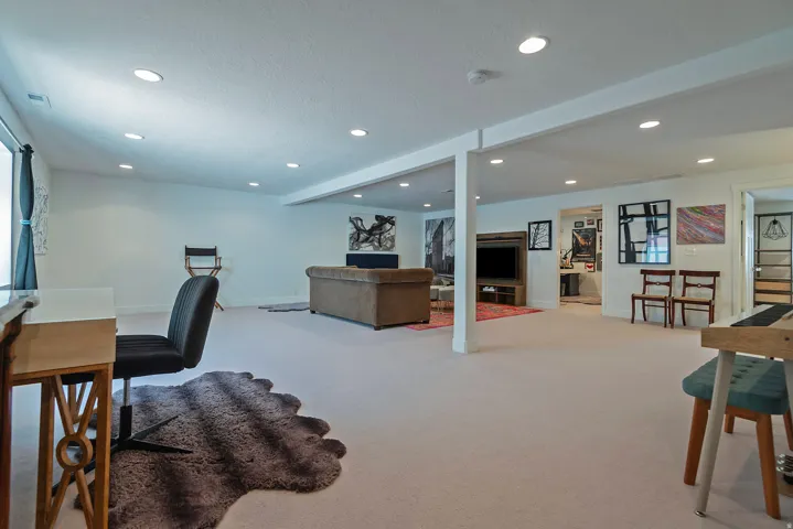 Spacious lower-level area with recessed lighting, light-toned carpeting, and white walls