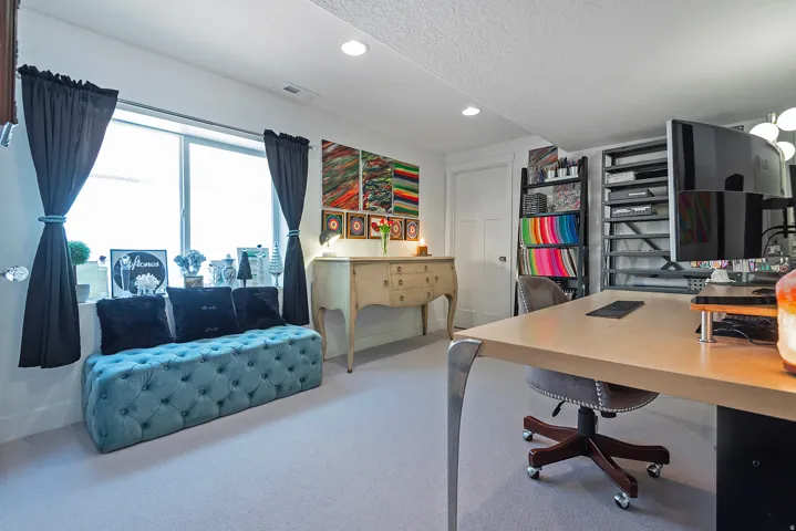 Bright room featuring a large window with white trim, recessed lighting, and a neutral carpeted floor