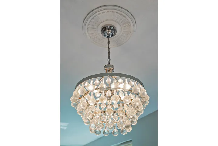 Teardrop crystal chandelier featuring a circular chrome frame and a decorative ceiling medallion