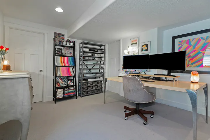 Dedicated workspace featuring neutral carpeting, recessed lighting, and a paneled white door