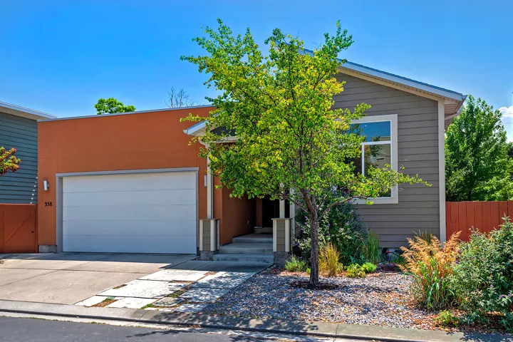 Contemporary exterior with a smooth orange stucco facade and gray horizontal siding