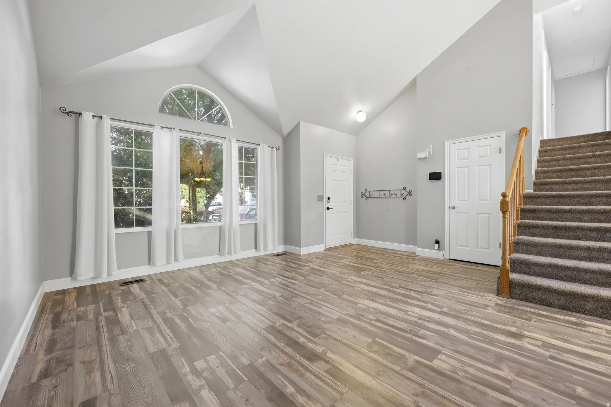 Spacious interior featuring vaulted ceilings and wood-finish flooring