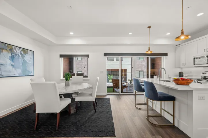 Open concept living space featuring wood-finish flooring, recessed lighting, and a private balcony