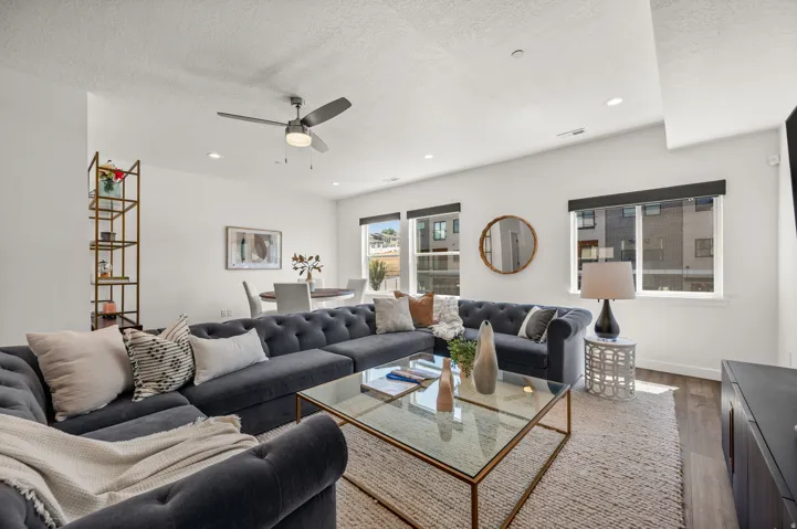 Open-concept living area with wood-finish flooring and ample natural light from multiple windows