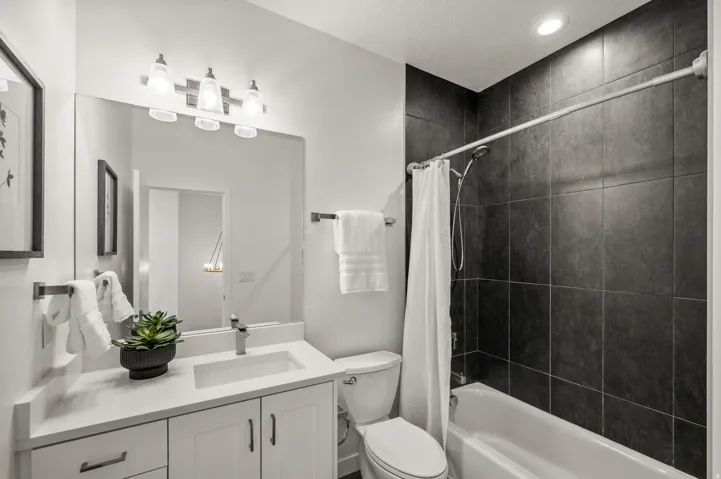 Bathroom featuring a white vanity with an integrated sink, brushed nickel faucet, and a large mirror