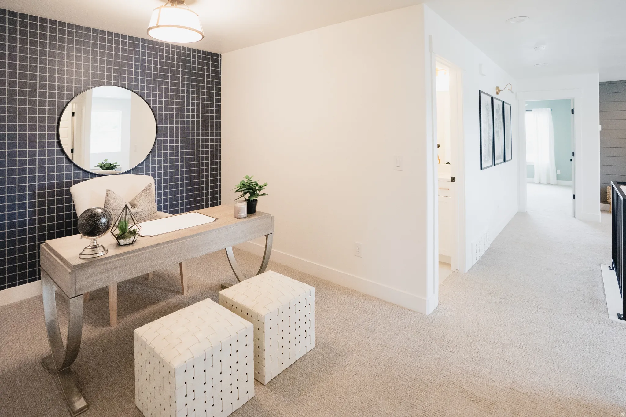 Dedicated space featuring an accent wall with square grid pattern and a ceiling-mounted light fixture