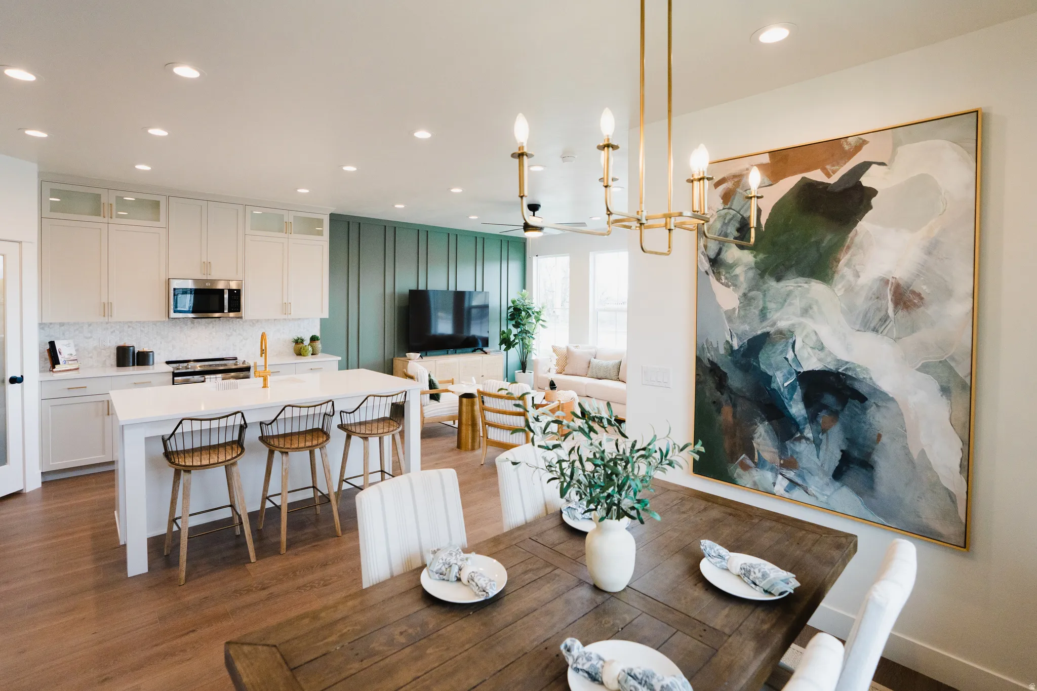 Open-concept living area featuring a kitchen island with seating, stainless steel appliances, wood-finish flooring, and recessed lighting