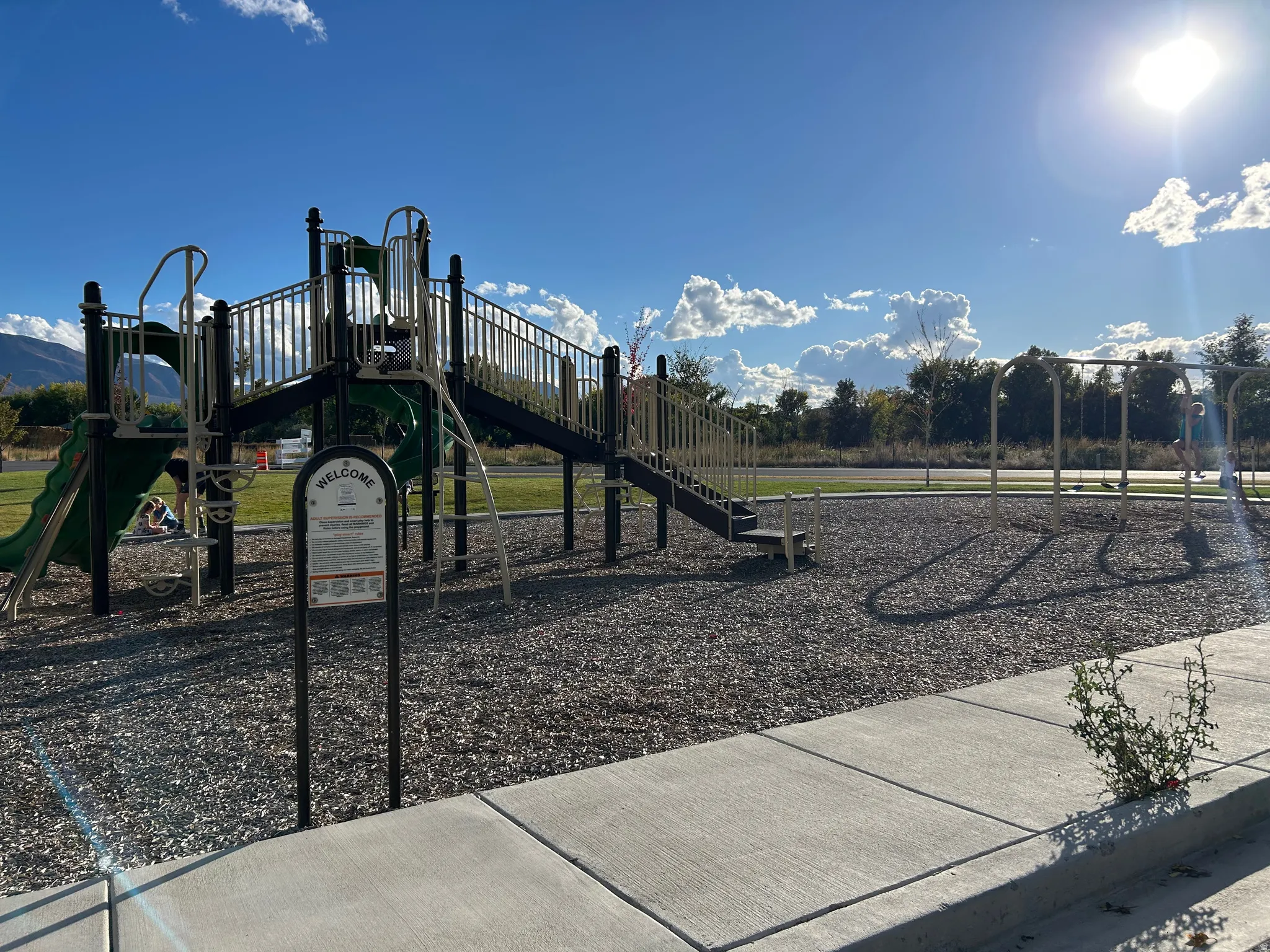 Community playground featuring a multi-level structure with slides, stairs, and safety railings