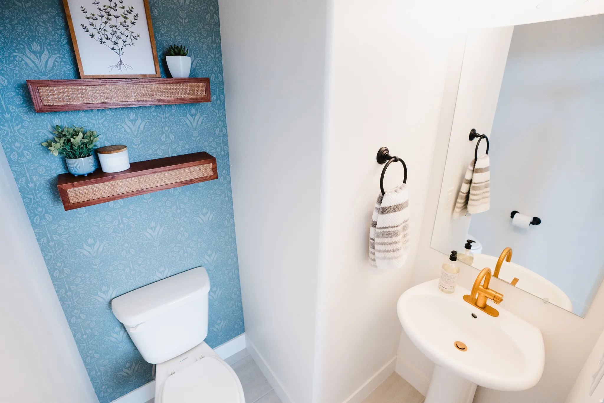 Pedestal sink with gold-finish faucet and coordinated drain