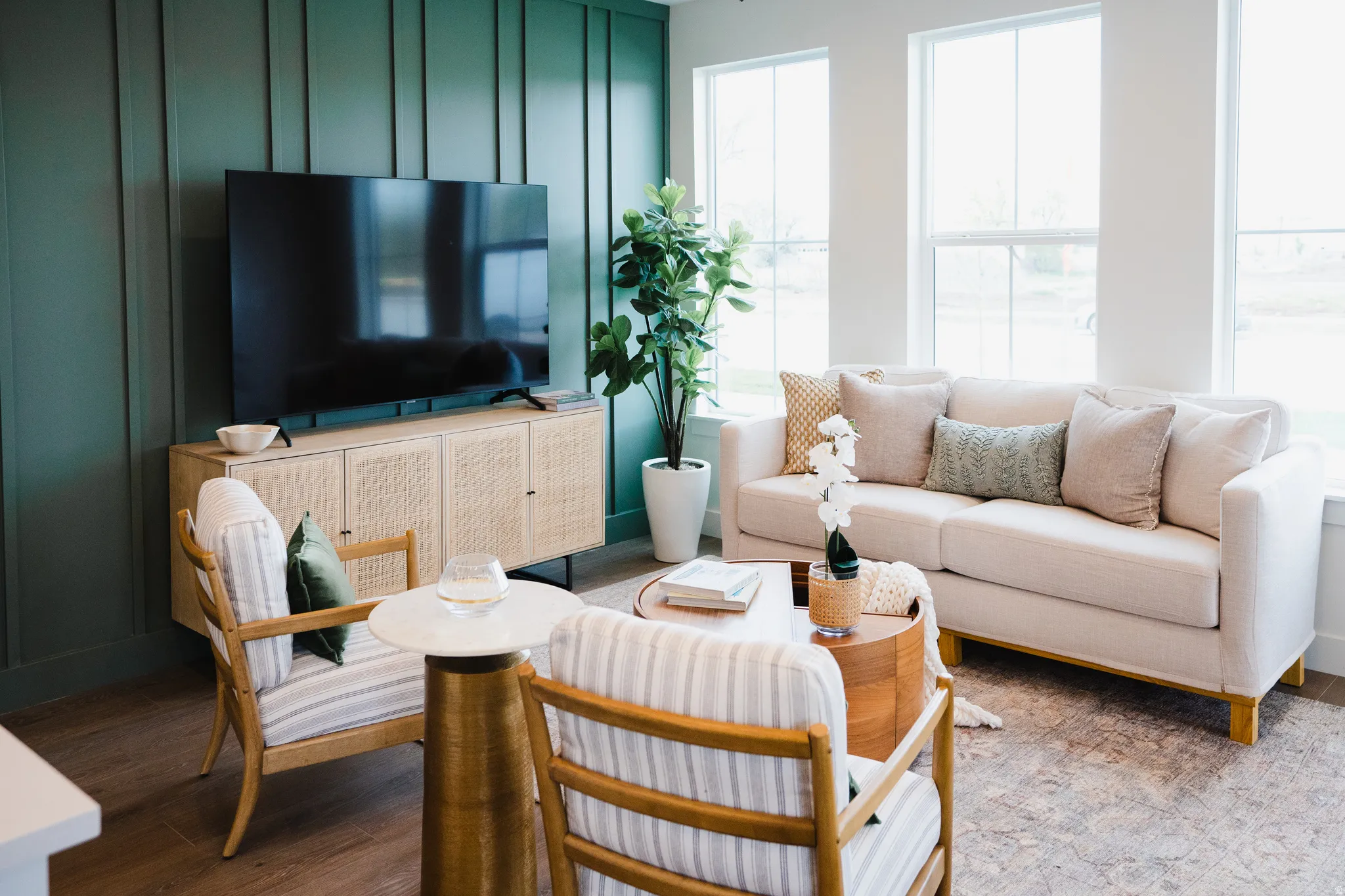 Living area featuring a floor-to-ceiling accent wall with vertical paneling, multiple large windows, and wood-finish flooring