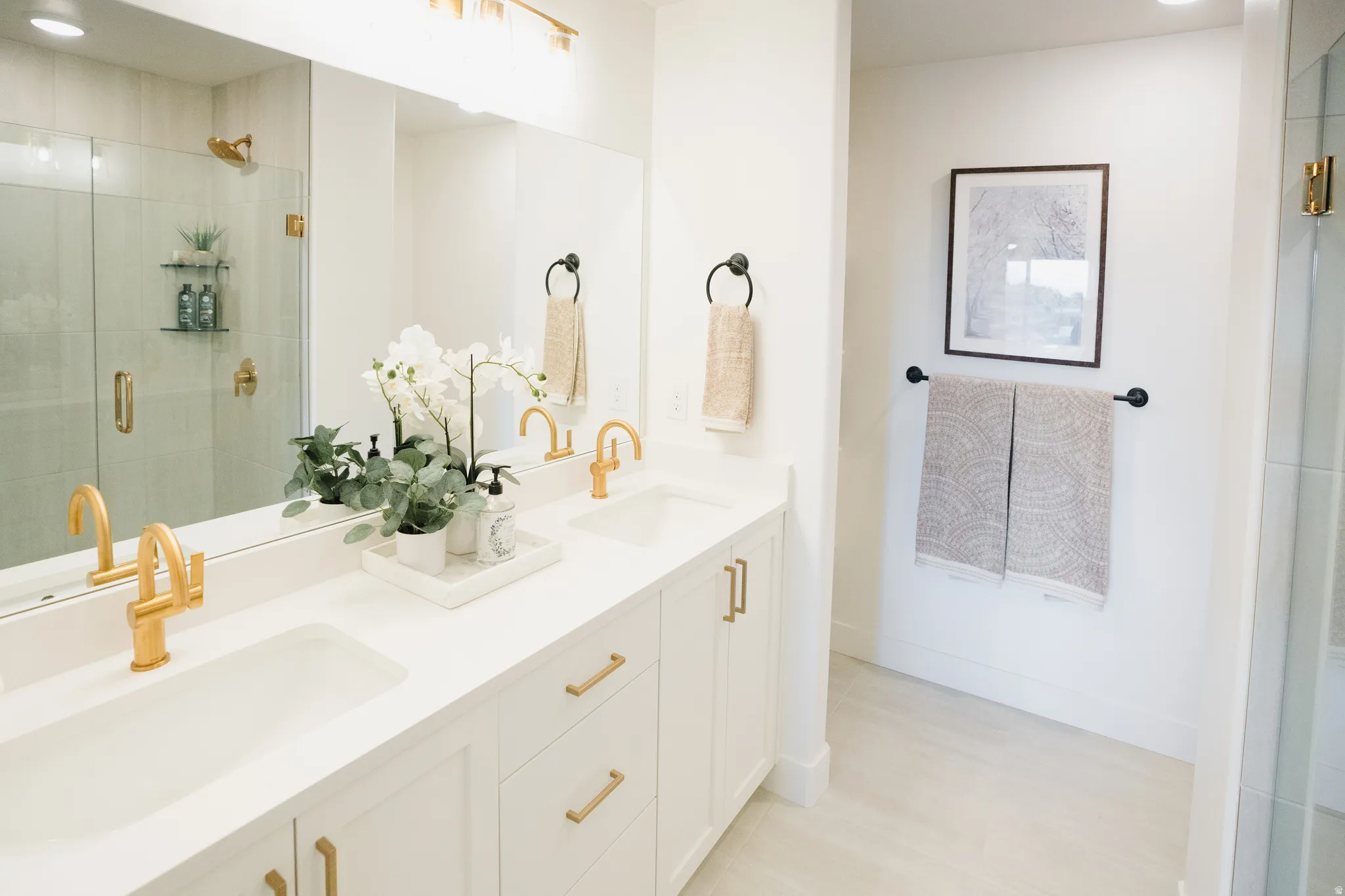 Double vanity with integrated sinks and gold-finish faucets