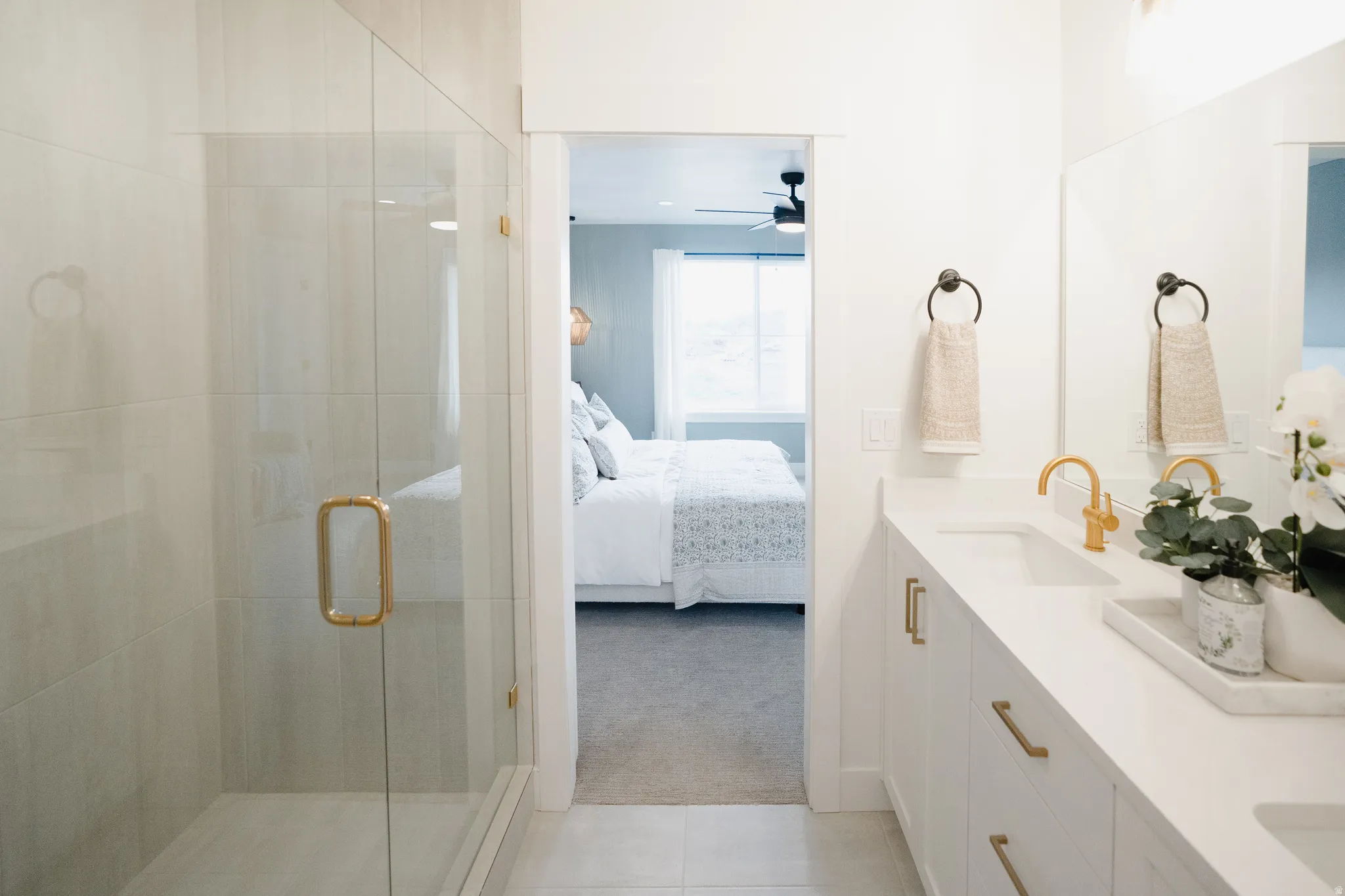 Modern bathroom vanity featuring dual sinks, white cabinetry, and brushed gold fixtures