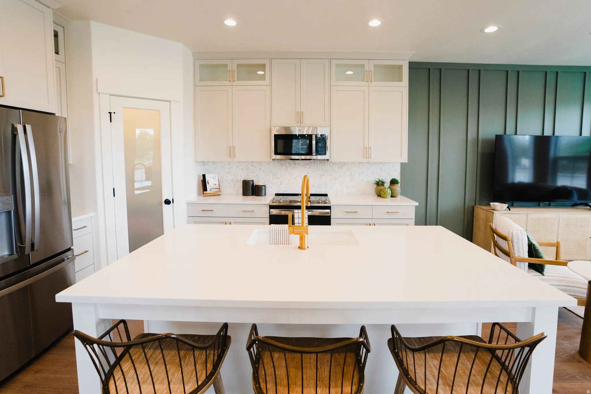 Expansive kitchen island with an integrated sink and gold-finish faucet