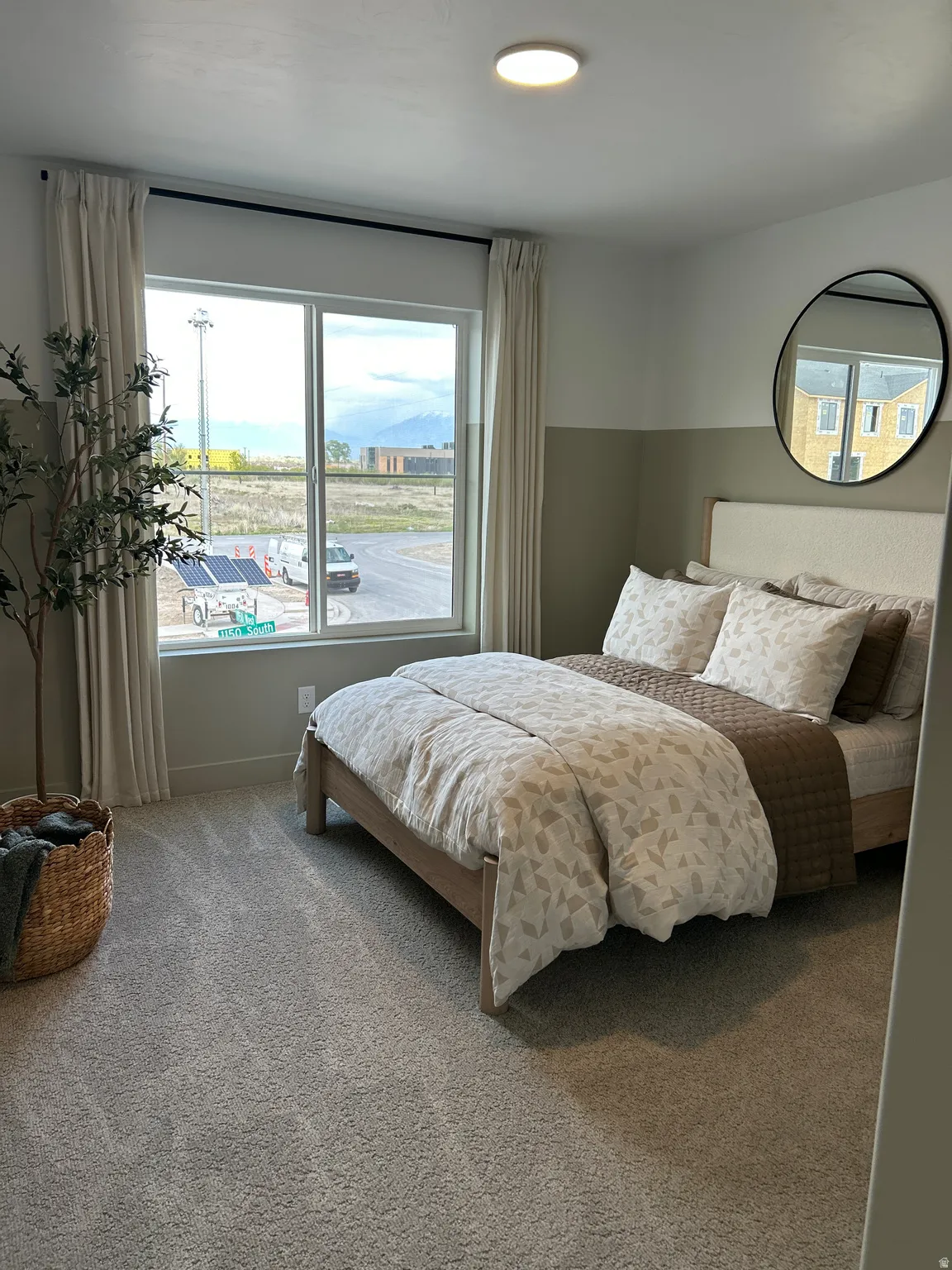 Bedroom featuring a large window, plush carpet flooring, a flush-mount ceiling light, and a two-tone painted wall