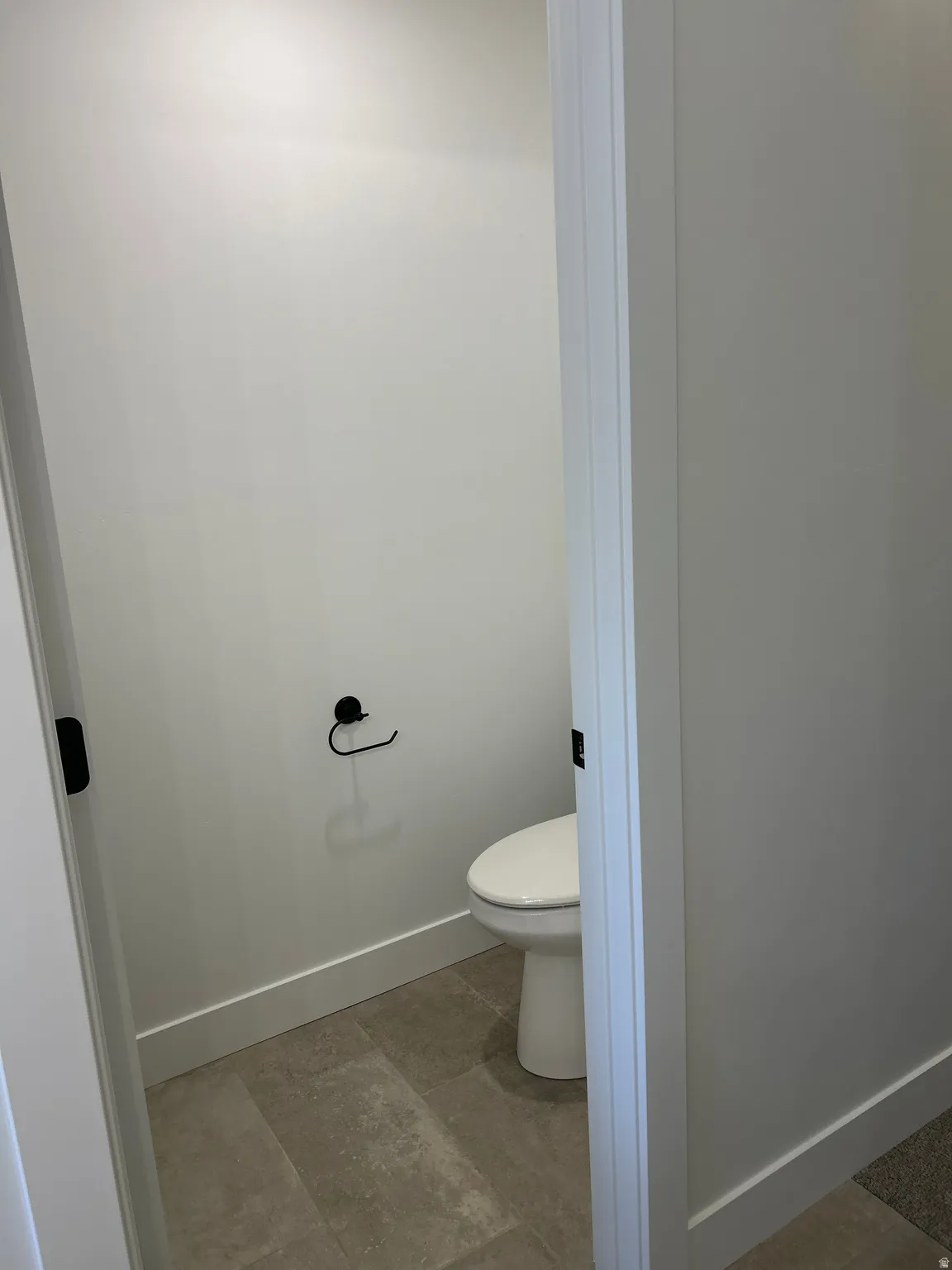 Private water closet featuring a contemporary toilet and matte black hardware