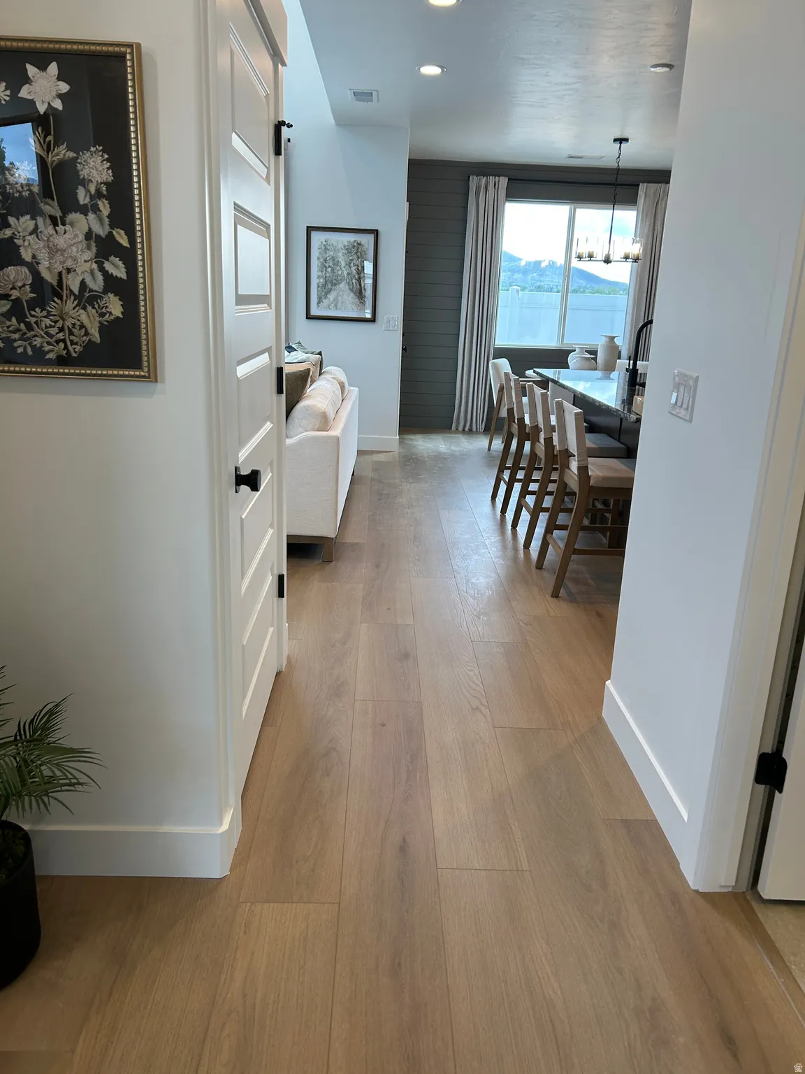 Open-concept living area featuring wood-finish flooring, recessed lighting, and white baseboards