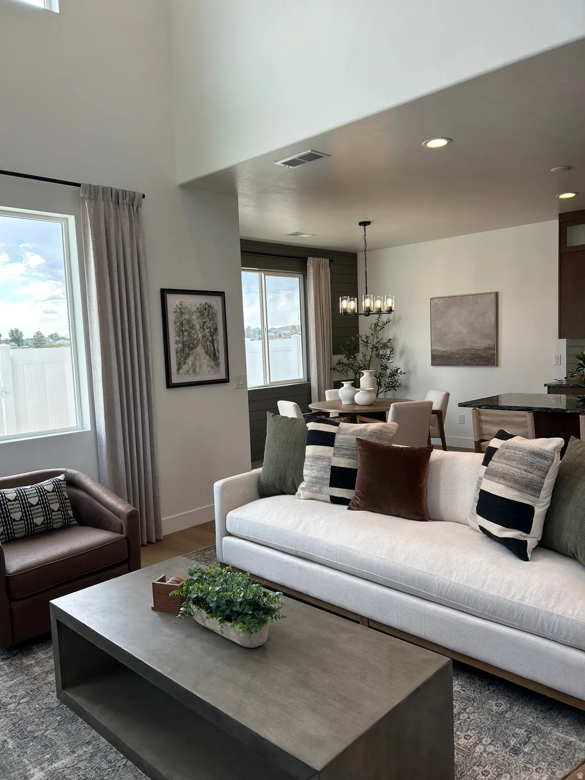 Spacious living area featuring high ceilings and abundant natural light from large windows