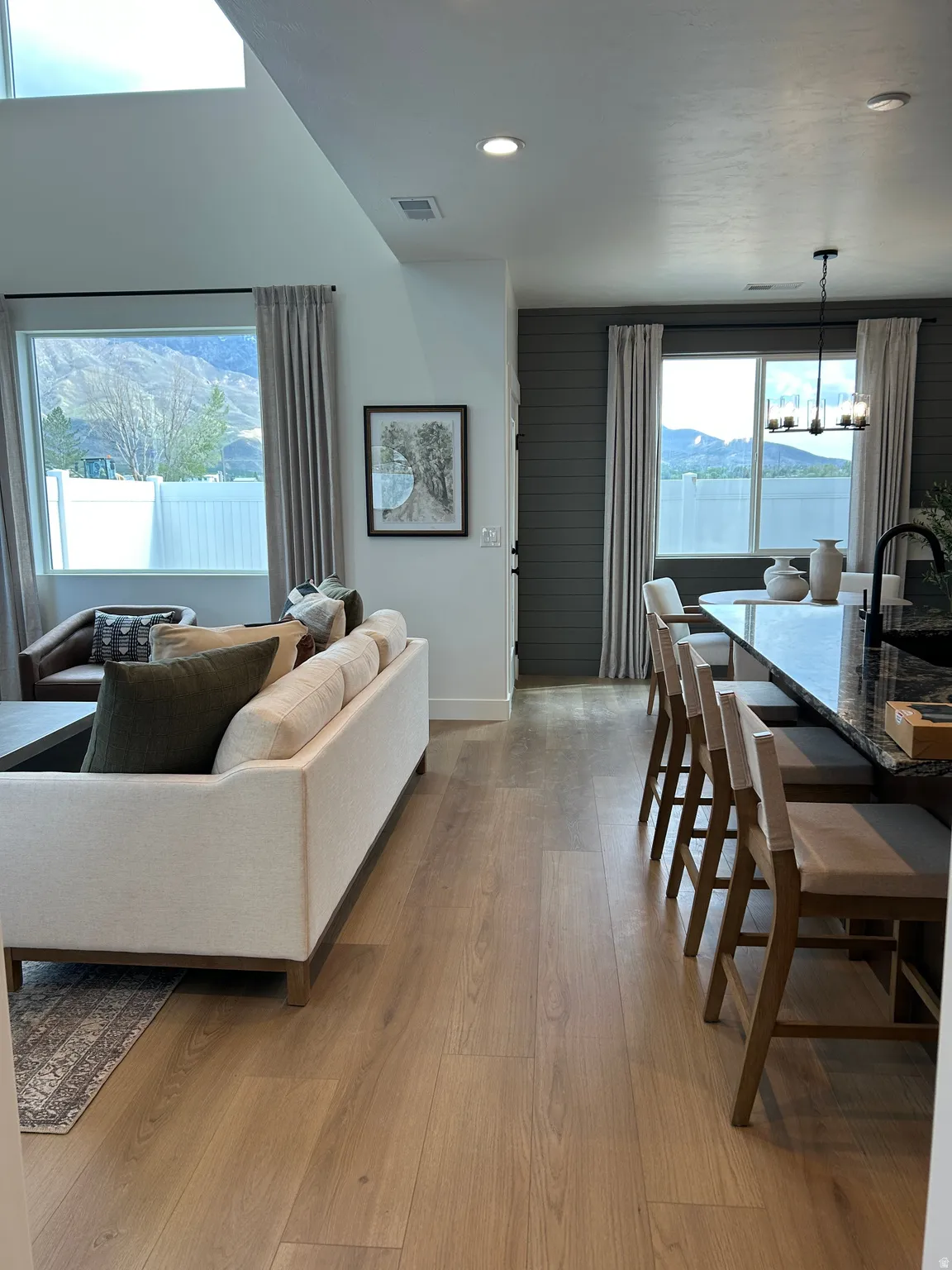Open-concept living space featuring wood-finish flooring, recessed lighting, and large windows with mountain scenery