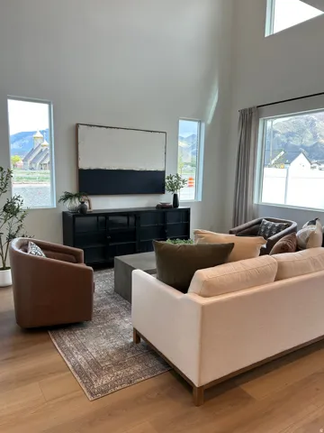 Living area with high ceilings, multiple windows, and wood-finish flooring